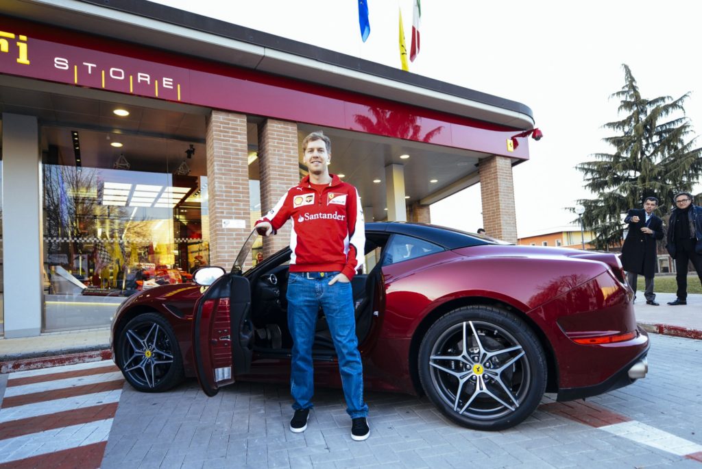 Vettel vor einem Ferrari in Maranello. Copyright: Ferrari